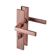 Mat koperen Collodi deurklink 245 × 45 mm op lang schild met WC-slot hartafstand 63 mm voor badkamerdeuren