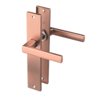 Mat koperen Collodi deurklink op blind lang schild 245 × 45 mm met geveerde terugveeractie 
