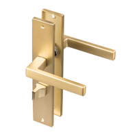Mat gouden Alassio deurklink op lang schild met geïntegreerd WC-slot en hartafstand 63 mm 
